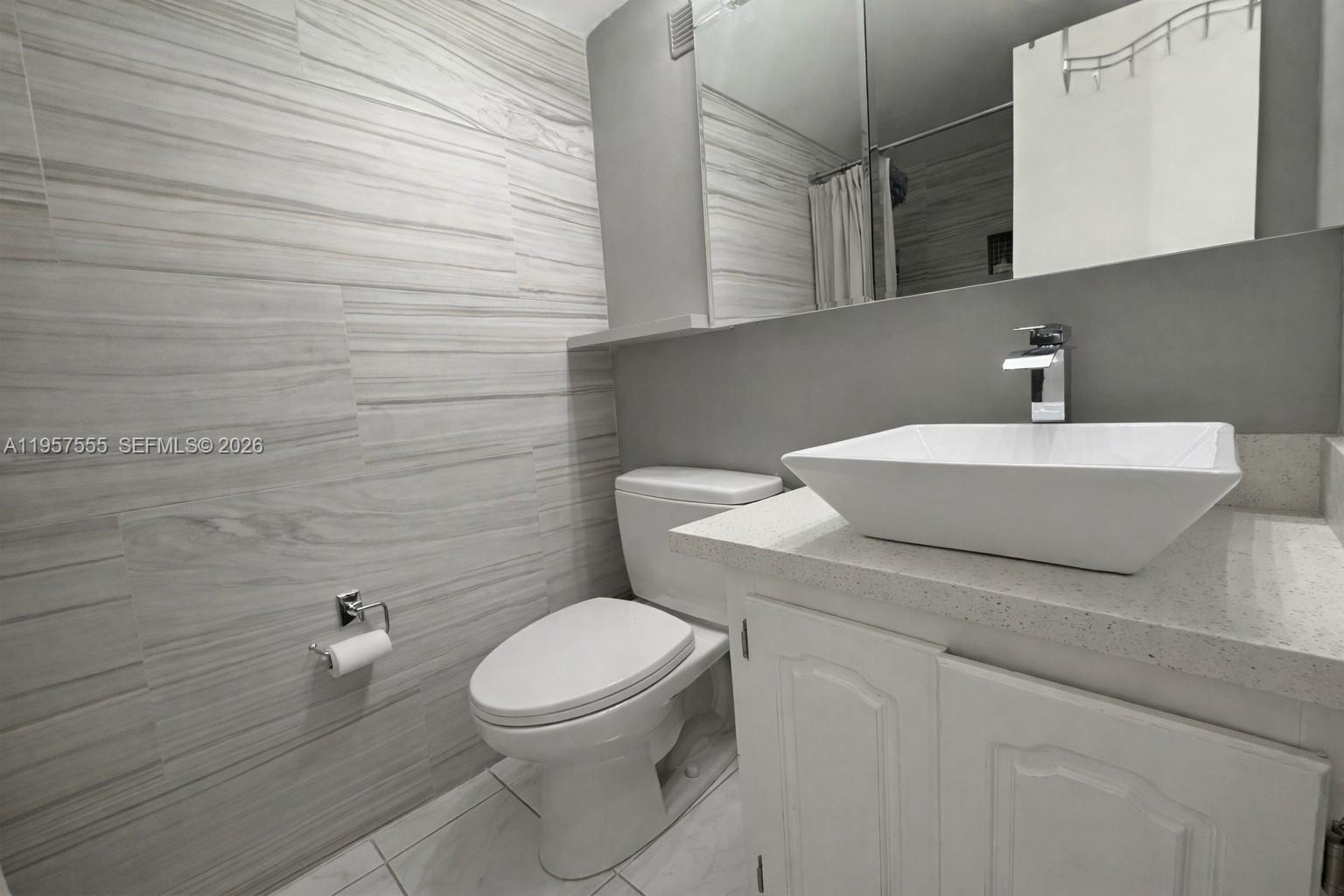 3910 Inverrary Boulevard, Unit 603B Lauderhill, FL 33319 - Photo 6 of 10 a white toilet sitting next to a bathroom sink