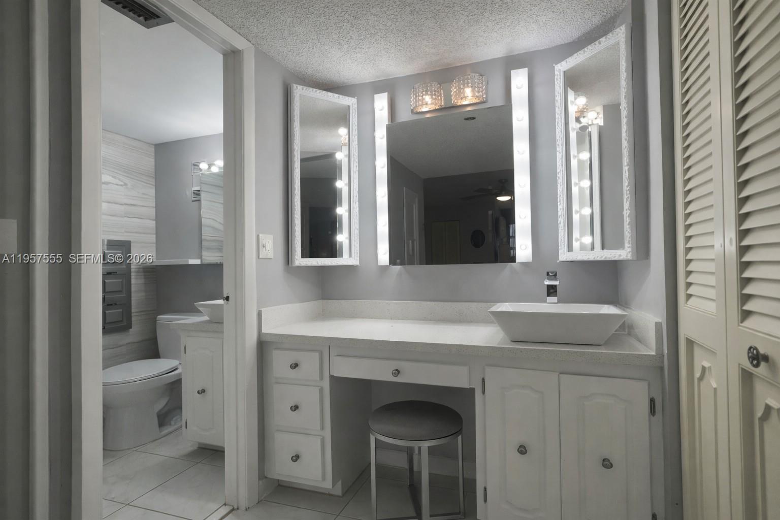 3910 Inverrary Boulevard, Unit 603B Lauderhill, FL 33319 - Photo 7 of 10 a bathroom with a toilet a sink and mirror
