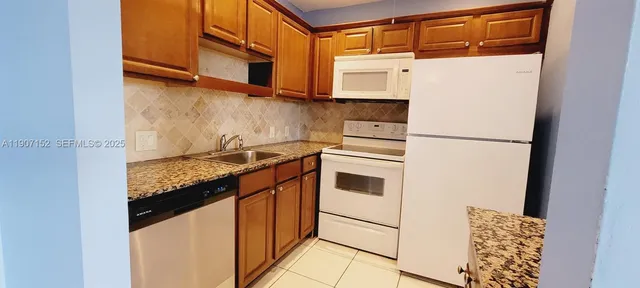 a kitchen with stainless steel appliances granite countertop a refrigerator and a stove