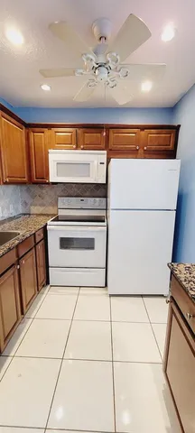 a kitchen with a refrigerator a stove top oven a sink and dishwasher
