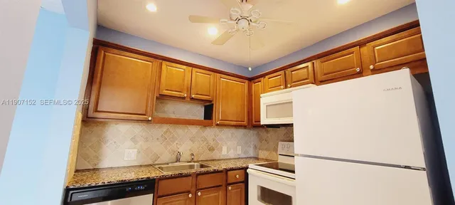 a kitchen with stainless steel appliances granite countertop a refrigerator and a stove top oven