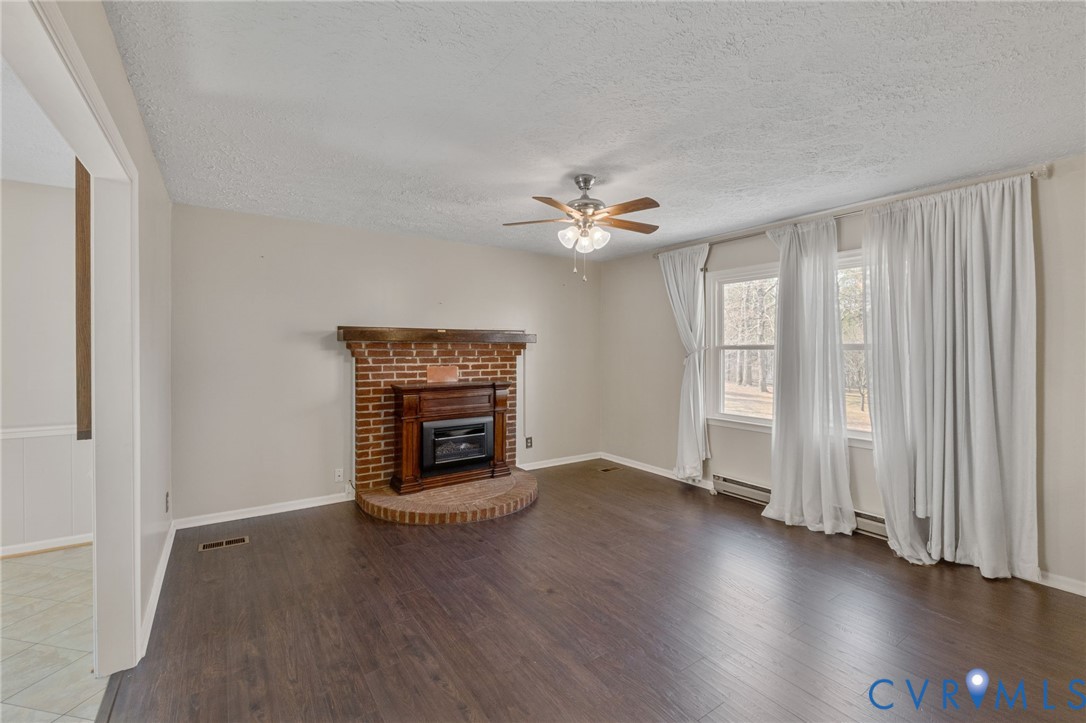 270 Long Acre Road Palmyra, VA 22963 - Photo 2 of 19 an empty room with wooden floor fireplace and windows