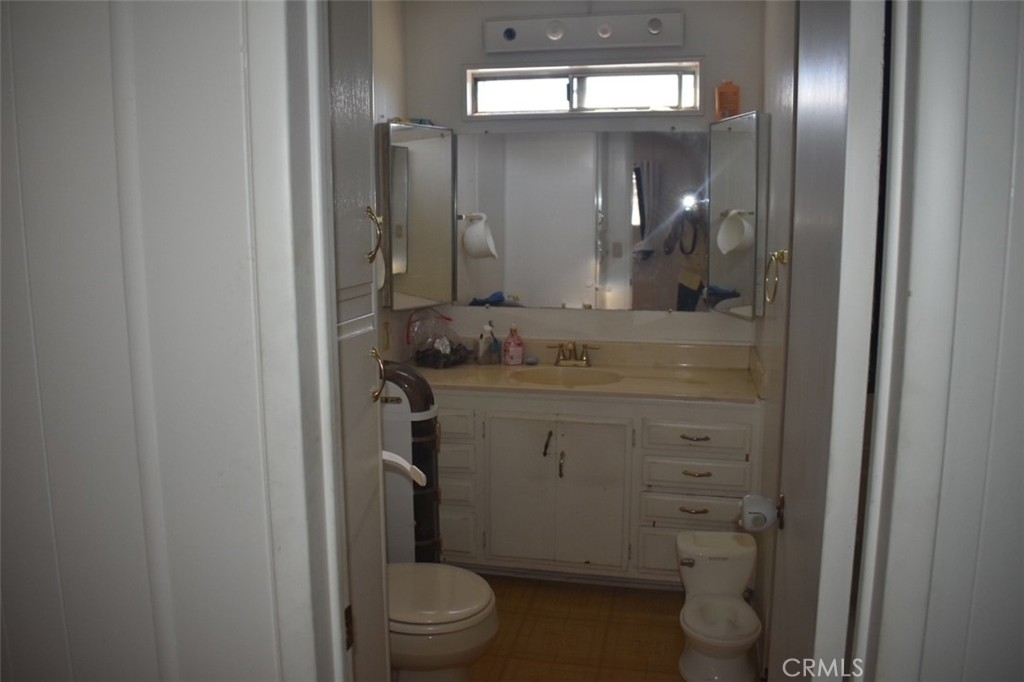 525 North Gilbert, Unit 106 Anaheim, CA 92801 - Photo 12 of 18 a bathroom with a granite countertop toilet sink and mirror