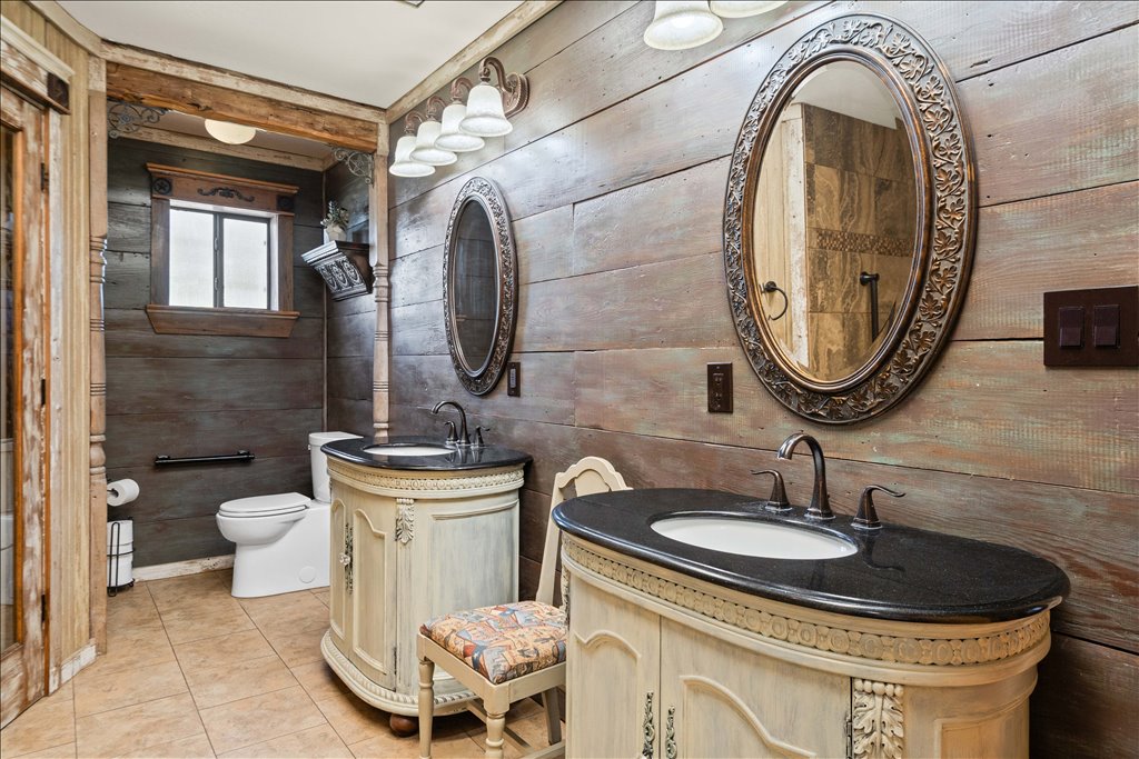 2421 Post Oak Road Webberville, TX 78653 - Photo 17 of 36 Check out these double vanities and the weathered wood paneling on the walls adds so much texture and character to the space.
