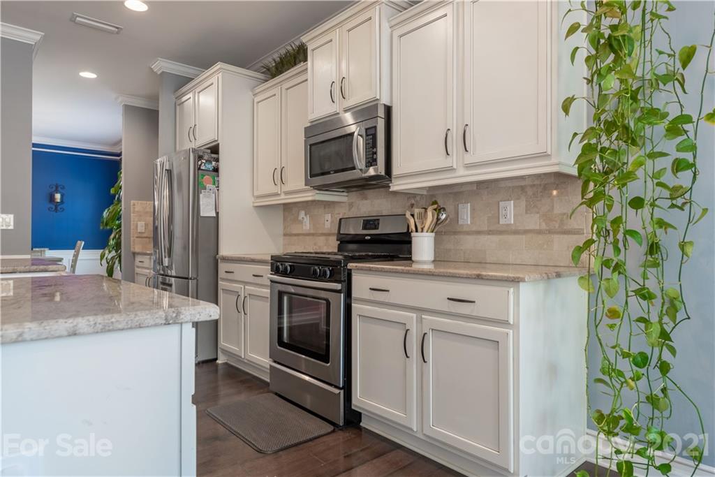 8049 Bryson Road, Unit 117 Indian Land, SC 29707 - Photo 17 of 40 a kitchen with stainless steel appliances granite countertop a stove a sink and a microwave