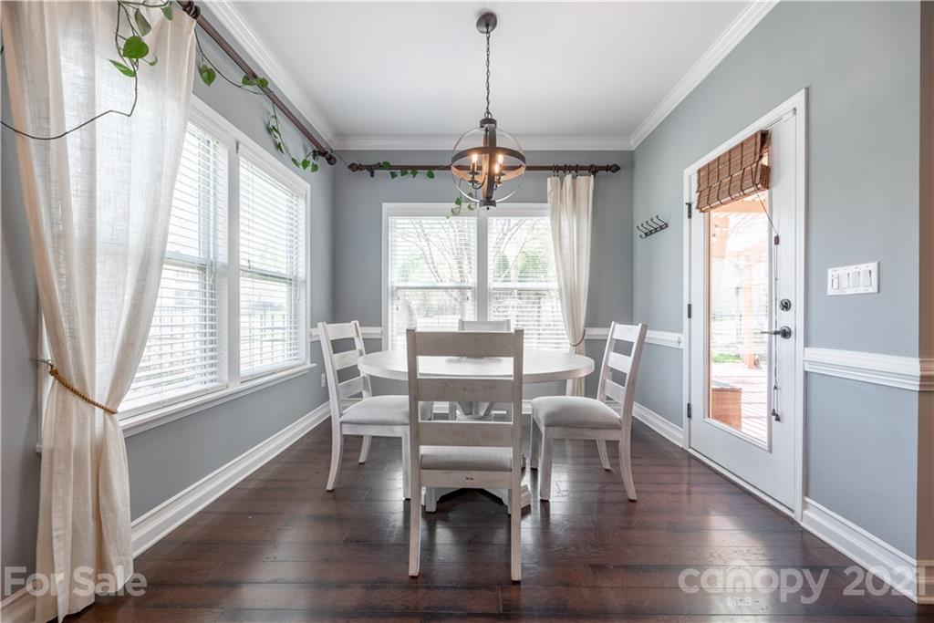8049 Bryson Road, Unit 117 Indian Land, SC 29707 - Photo 20 of 40 a view of a dining room with furniture wooden floor and a chandelier