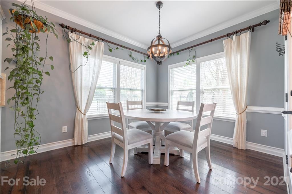 8049 Bryson Road, Unit 117 Indian Land, SC 29707 - Photo 21 of 40 a view of a dining room with furniture window and wooden floor