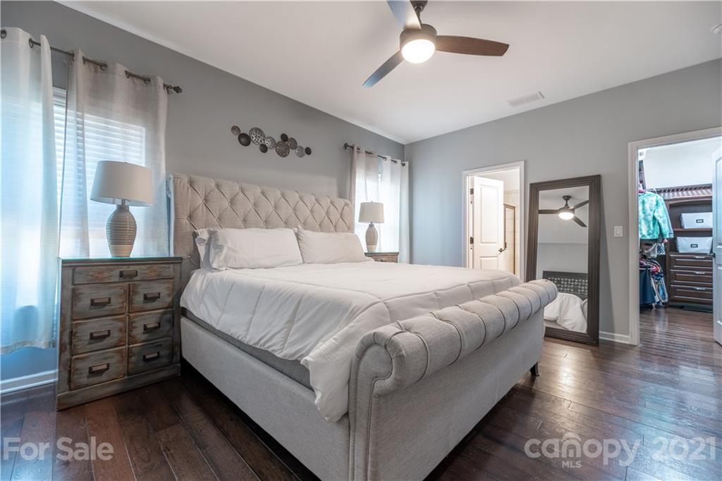 8049 Bryson Road, Unit 117 Indian Land, SC 29707 - Photo 27 of 40 a bedroom with a large bed and a chandelier