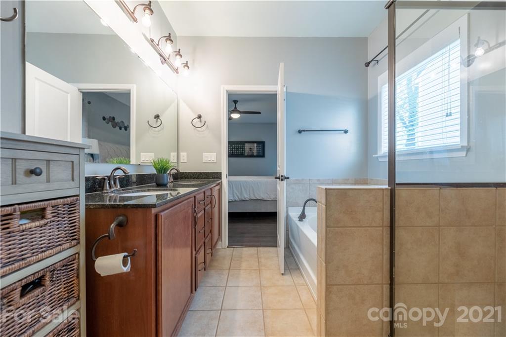 8049 Bryson Road, Unit 117 Indian Land, SC 29707 - Photo 32 of 40 a en suite bathroom with a granite countertop sink and a mirror