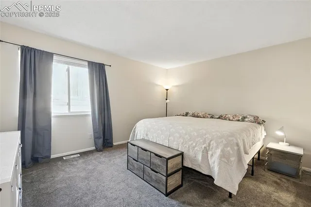 a bed sitting in a spacious bedroom next to a window