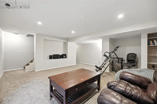 a living room with furniture a rug and white walls