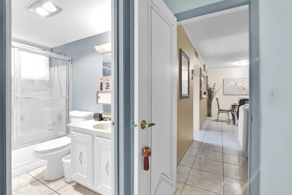 a bathroom with a granite countertop sink a toilet and shower