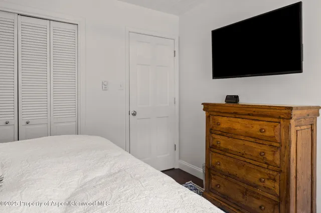 a bedroom with a bed and a flat tv screen in it