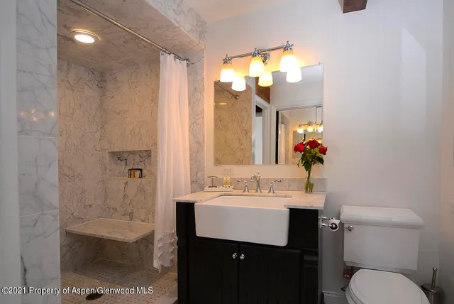 a bathroom with a sink a toilet and mirror