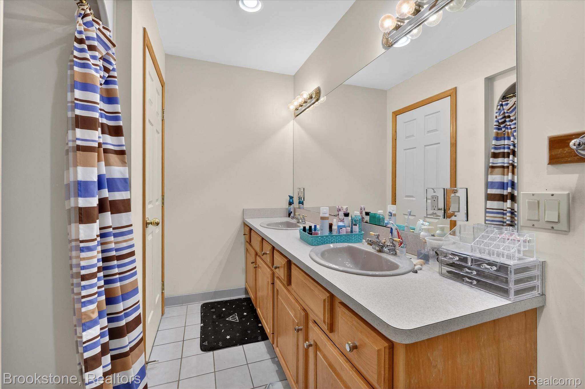 5163 Country Squire Road Dryden, MI 48428 - Photo 36 of 64 Bathroom featuring a shower with curtain, double vanity, and light tile patterned flooring