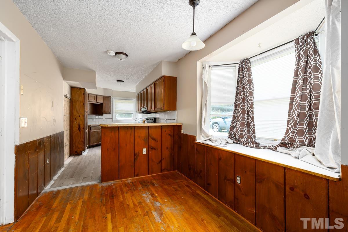 3003 Cheek Road Durham, NC 27704 - Photo 22 of 24 a kitchen with stainless steel appliances kitchen island granite countertop a refrigerator a sink dishwasher and wooden cabinets with wooden floor