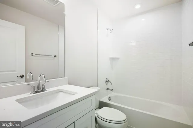 a kitchen with stainless steel appliances white cabinets and a refrigerator