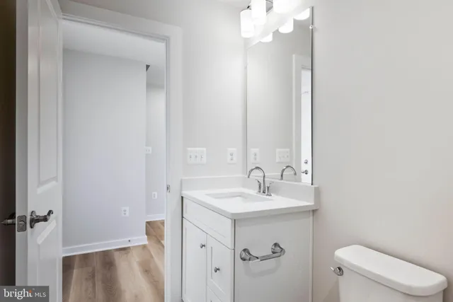 a view of a hallway with wooden floor and a living room