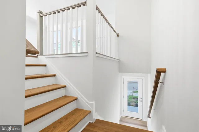 a view of a hallway with wooden floor and entryway