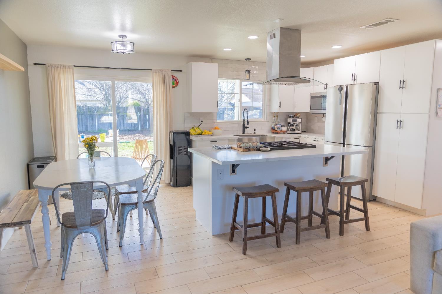 1612 Larry Street Olivehurst, CA 95961 - Photo 19 of 27 a kitchen with stainless steel appliances a table chairs refrigerator and cabinets
