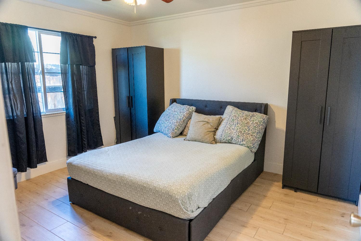 1612 Larry Street Olivehurst, CA 95961 - Photo 23 of 27 a large bed in a bedroom next to a window and a chandelier