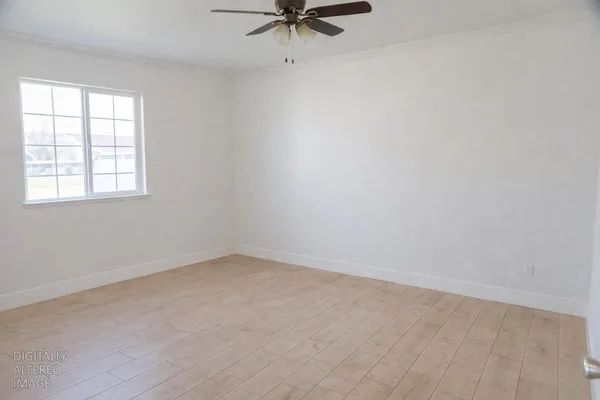 an empty room with a window and a ceiling fan