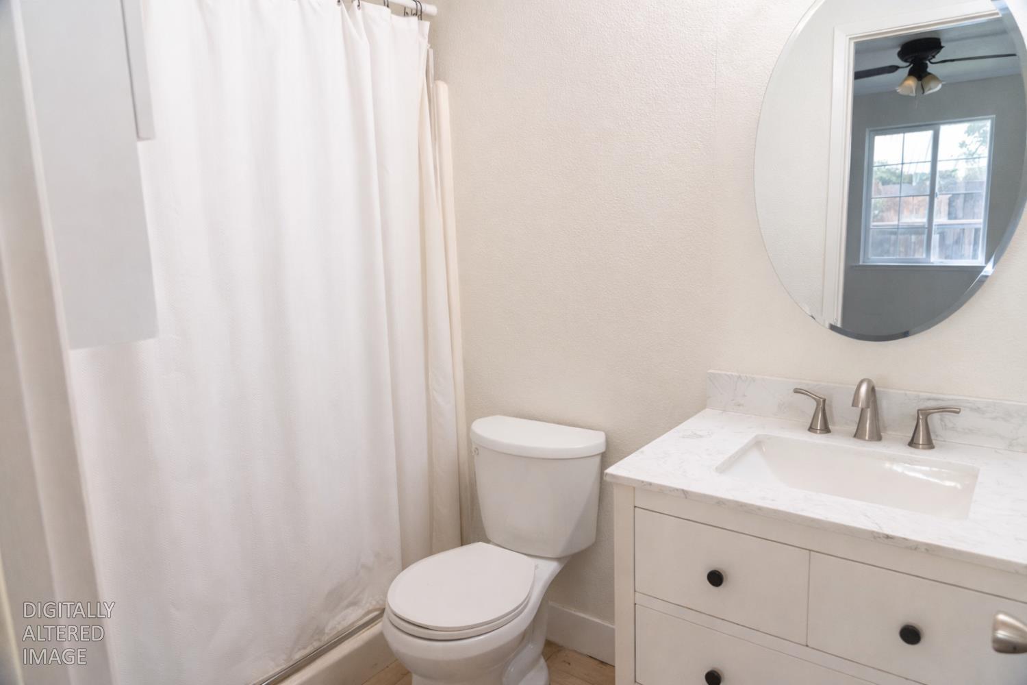 1612 Larry Street Olivehurst, CA 95961 - Photo 10 of 27 a bathroom with a toilet a sink and a mirror