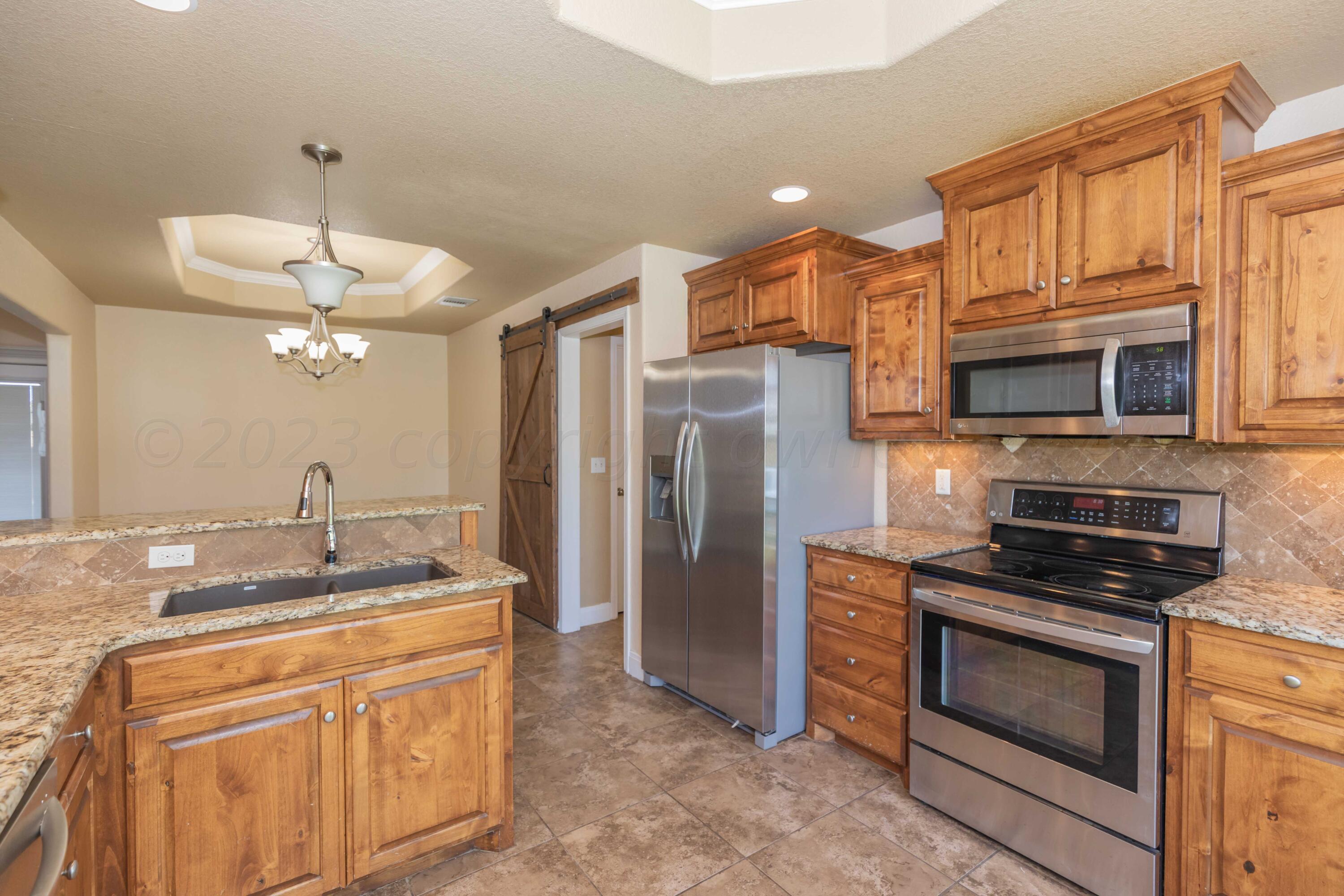 3904 Arden Road Amarillo, TX 79118 - Photo 11 of 45 a kitchen with stainless steel appliances granite countertop a stove a refrigerator and a microwave