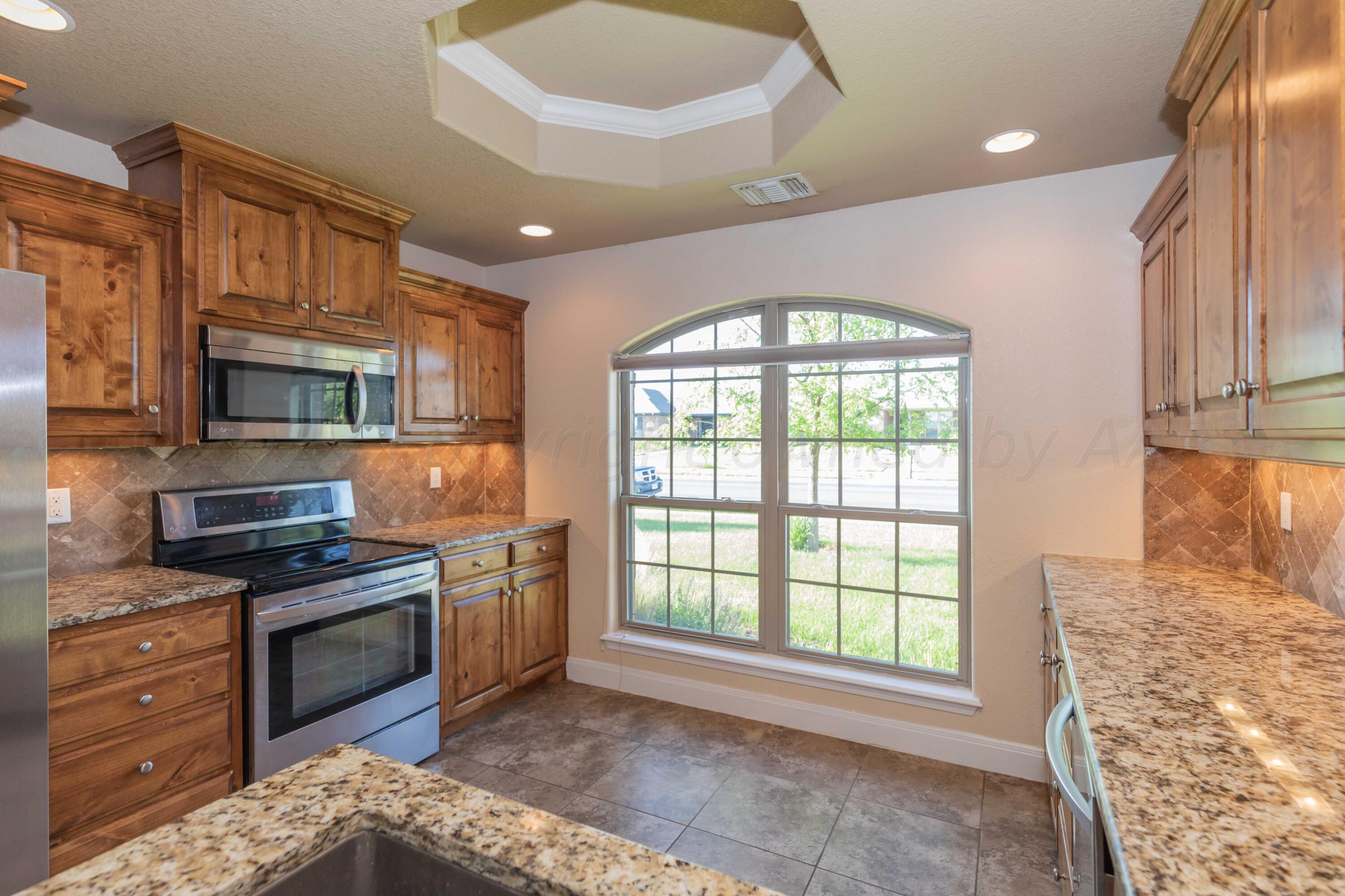 3904 Arden Road Amarillo, TX 79118 - Photo 13 of 45 a kitchen with stainless steel appliances granite countertop a stove a sink and a refrigerator