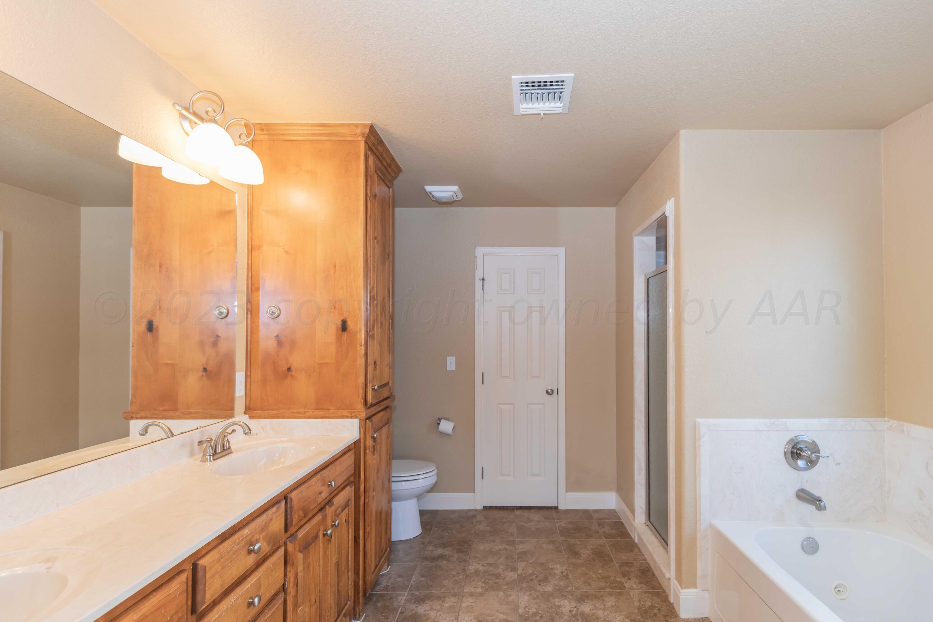3904 Arden Road Amarillo, TX 79118 - Photo 24 of 45 a bathroom with a tub sink and mirror