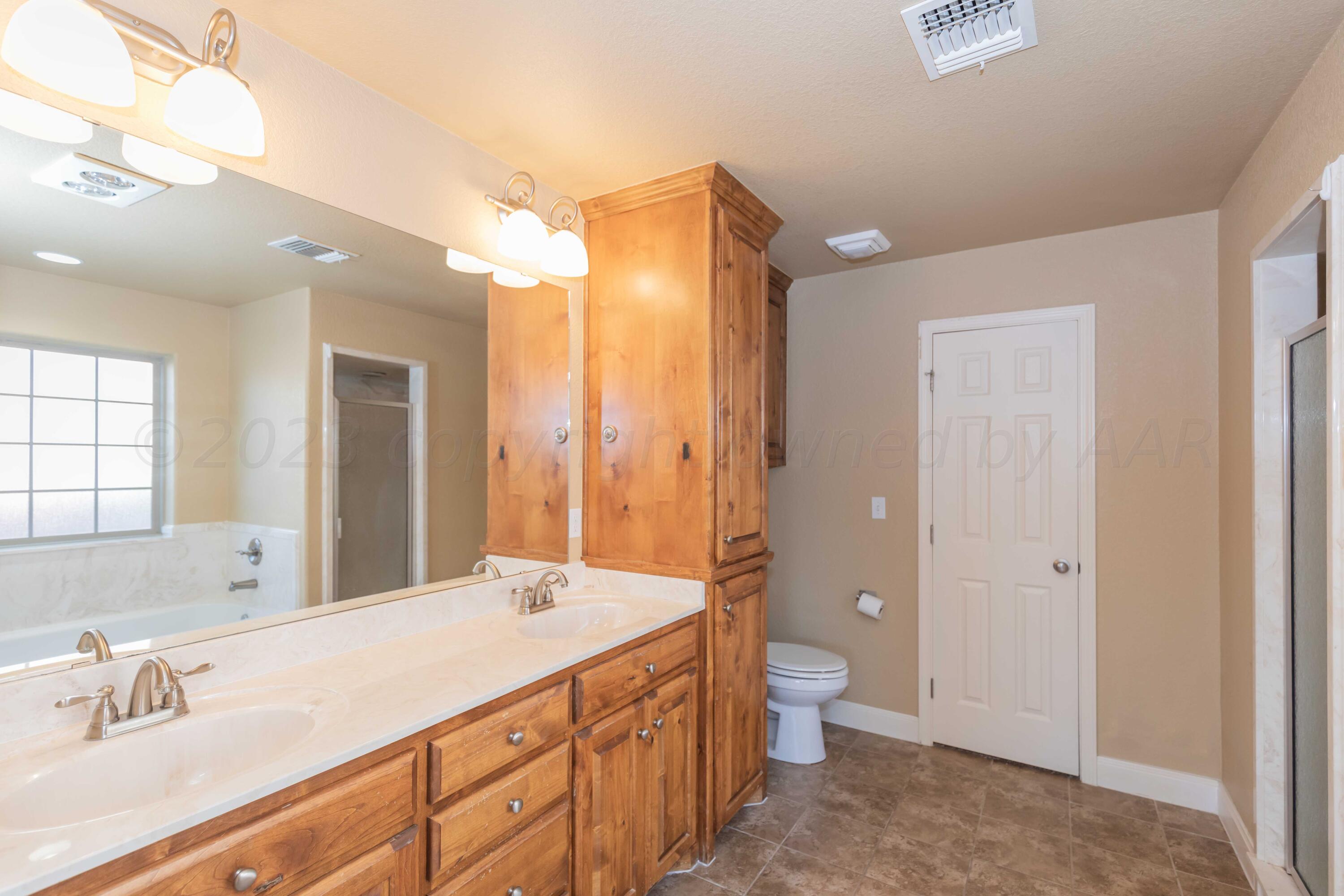 3904 Arden Road Amarillo, TX 79118 - Photo 25 of 45 a spacious bathroom with a double vanity sink toilet and shower