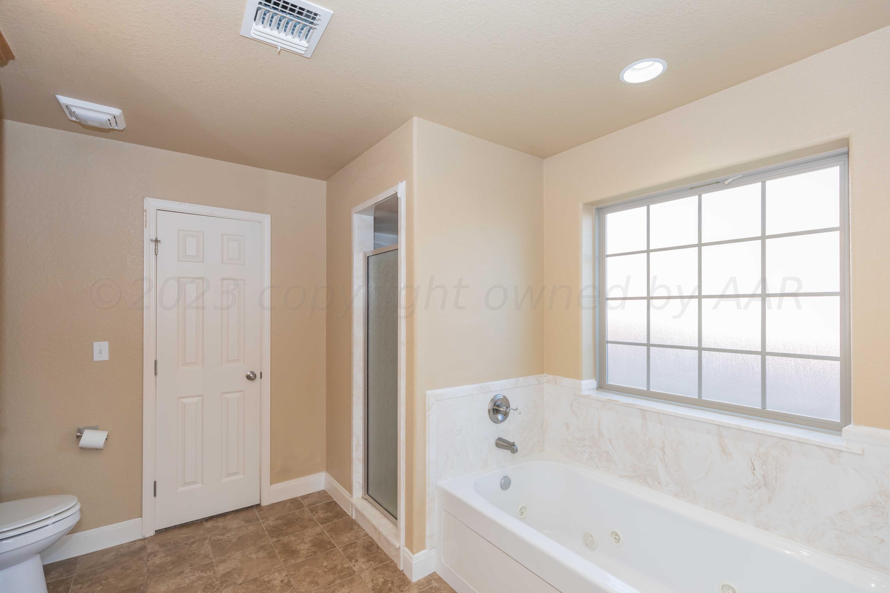 3904 Arden Road Amarillo, TX 79118 - Photo 26 of 45 a bathroom with a bathtub and a toilet