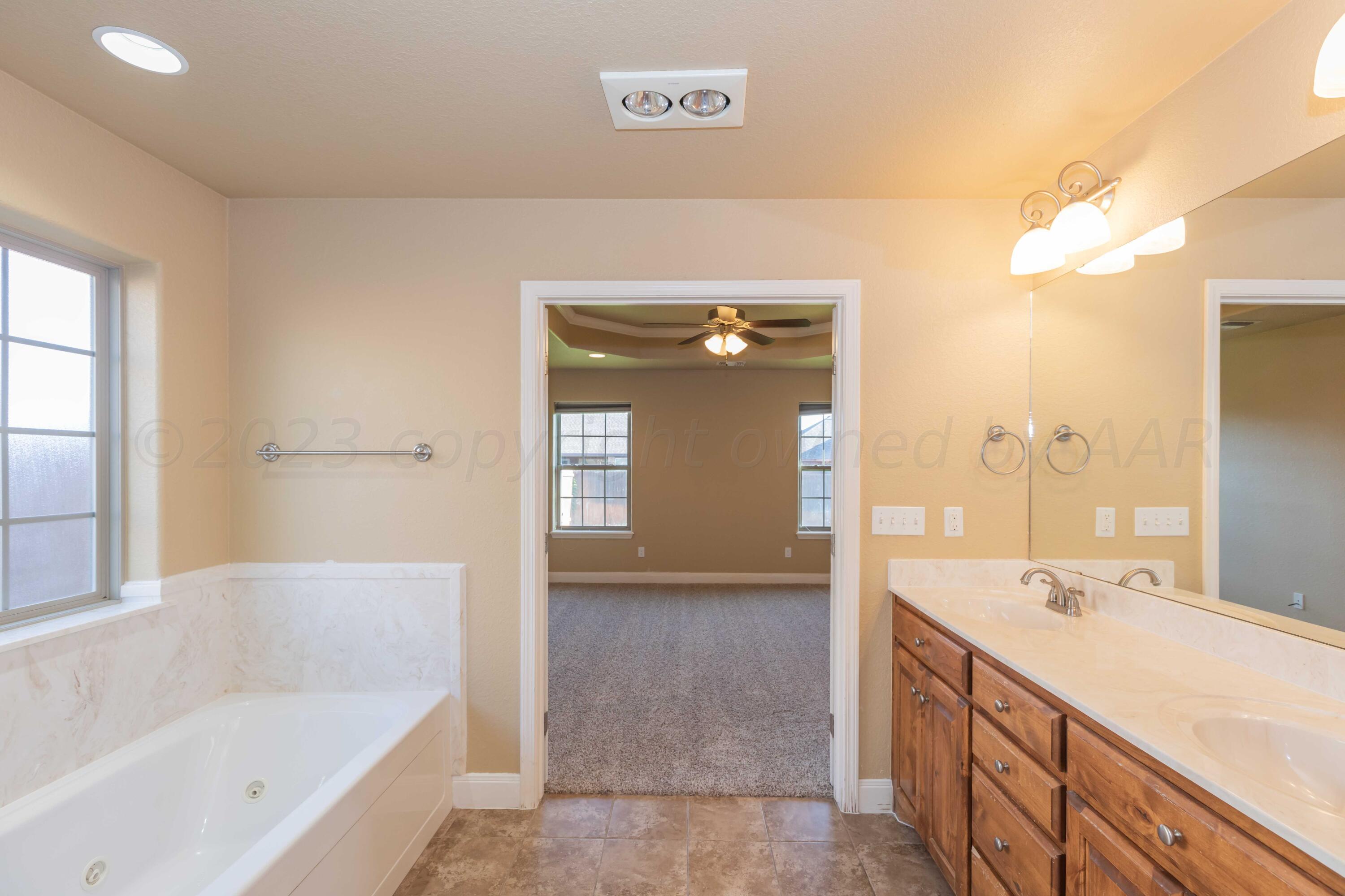 3904 Arden Road Amarillo, TX 79118 - Photo 28 of 45 a spacious bathroom with a tub sink and mirror