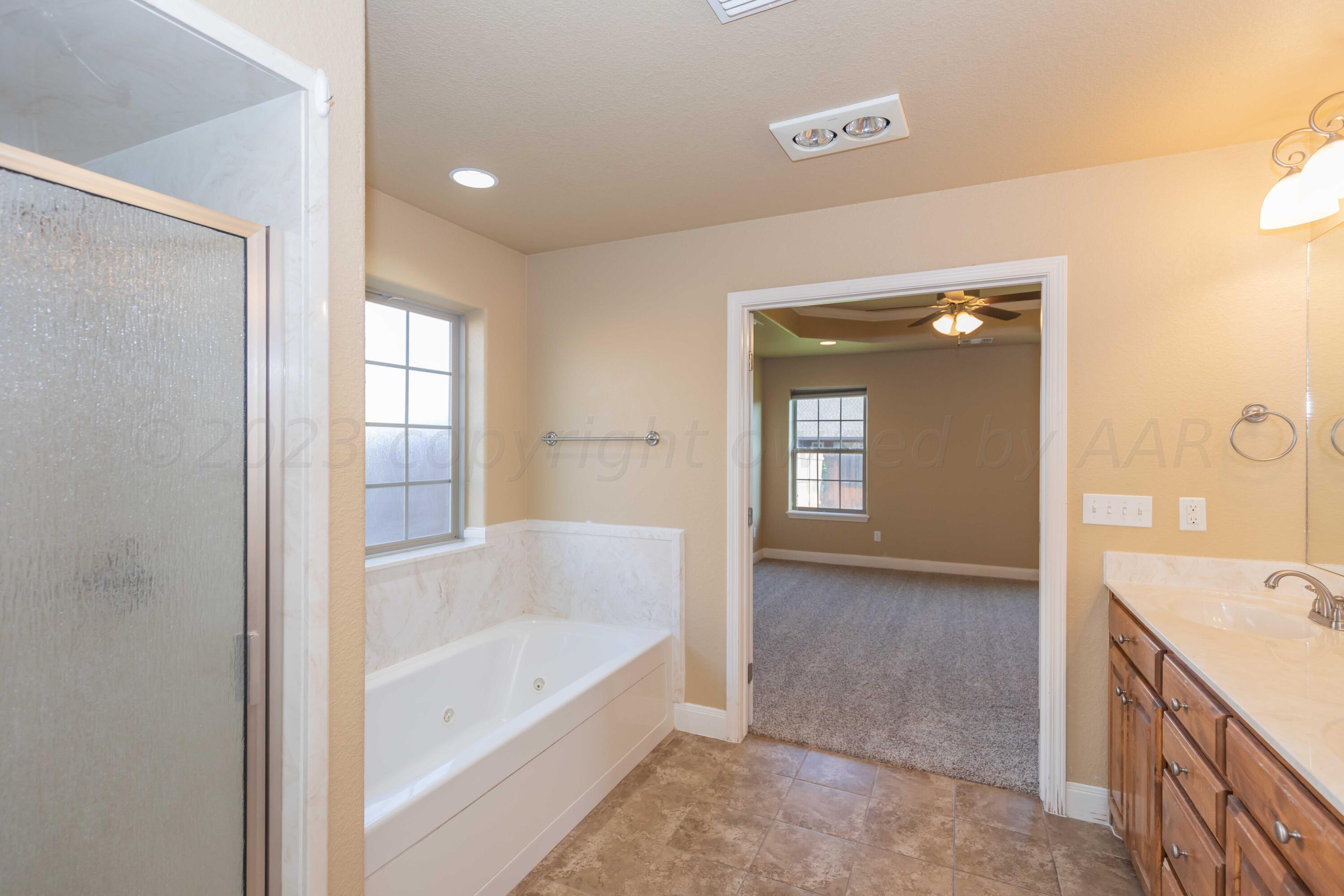 3904 Arden Road Amarillo, TX 79118 - Photo 29 of 45 a bathroom with a bathtub sink and mirror