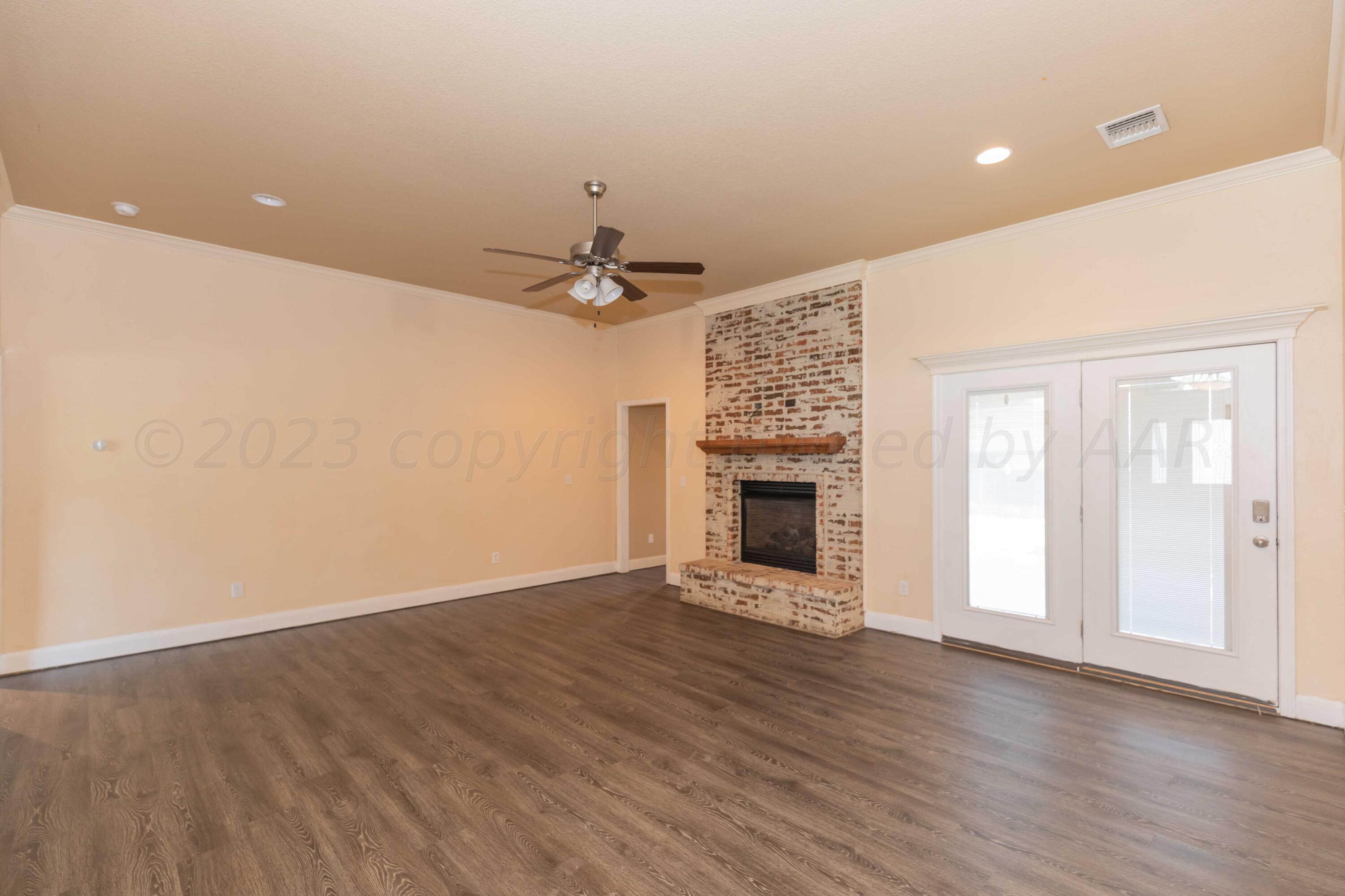 3904 Arden Road Amarillo, TX 79118 - Photo 5 of 45 an empty room with wooden floor and fireplace