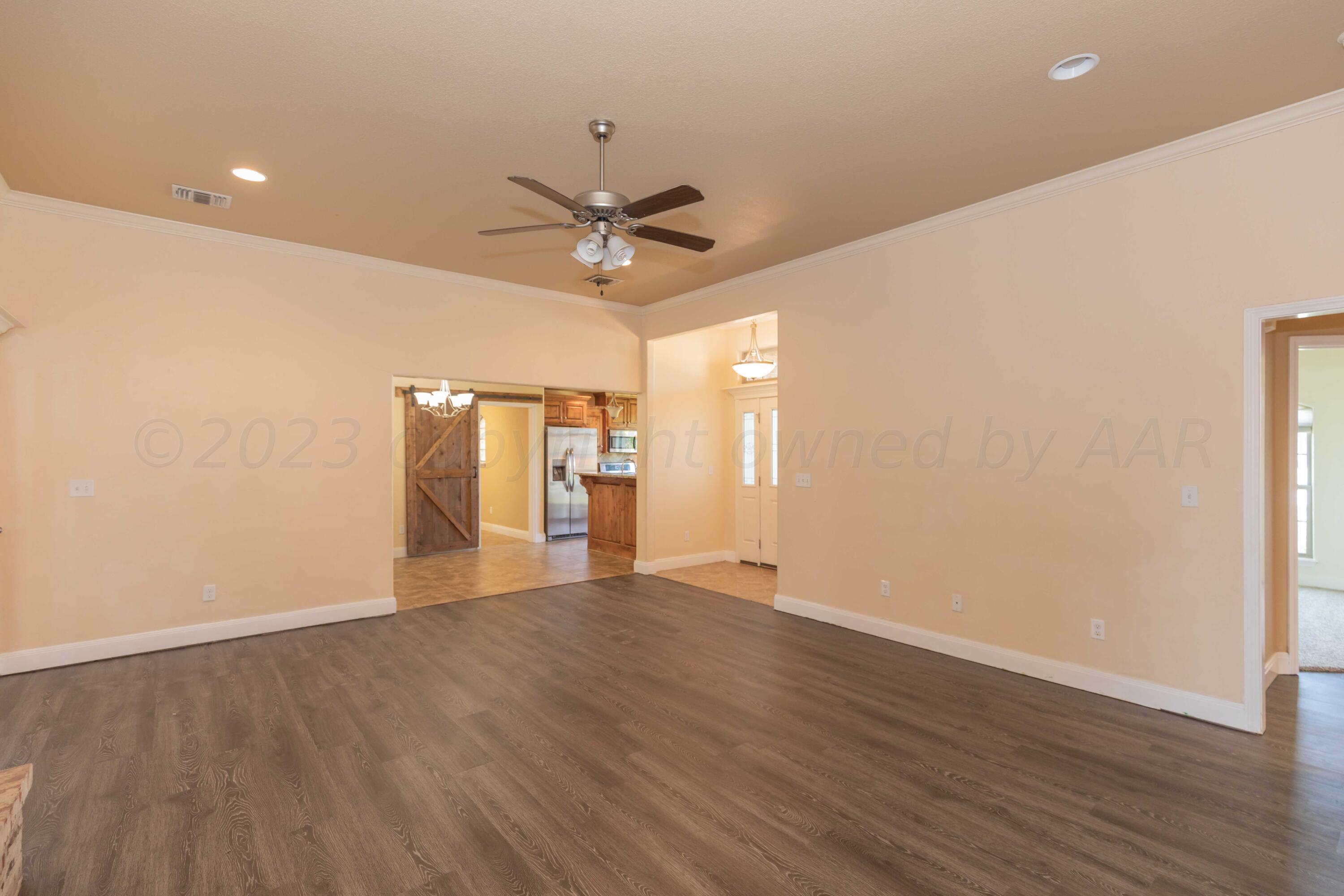 3904 Arden Road Amarillo, TX 79118 - Photo 8 of 45 a view of an empty room with wooden floor and a ceiling fan