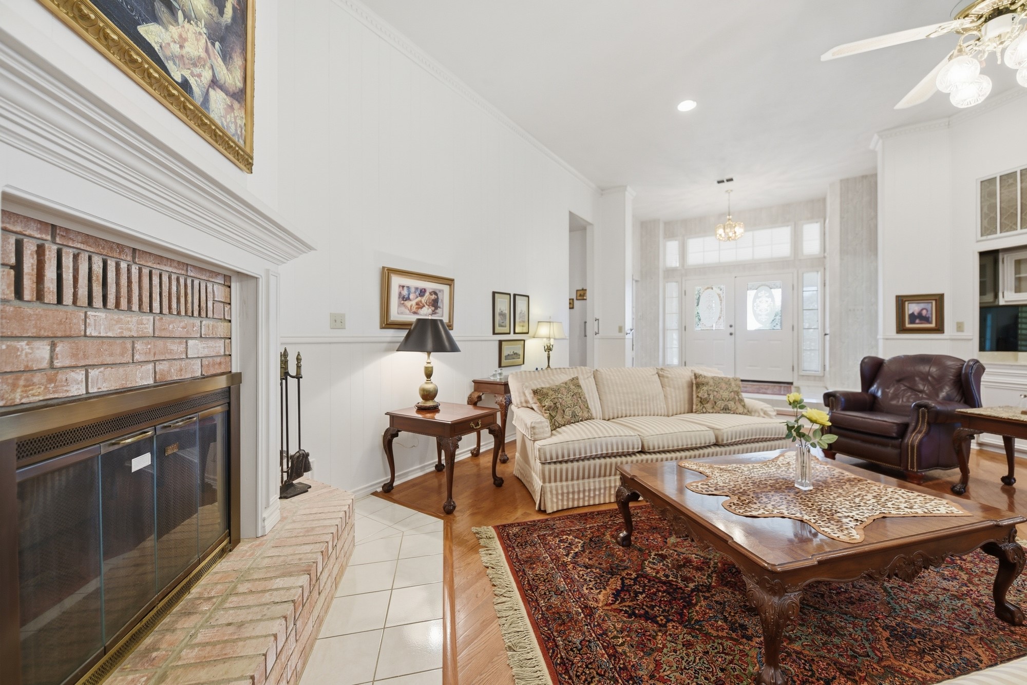 1552 Holub Road Schulenburg, TX 78956 - Photo 15 of 35 An inviting living room features a classic brick fireplace and rich hardwood flooring, creating a warm ambiance.