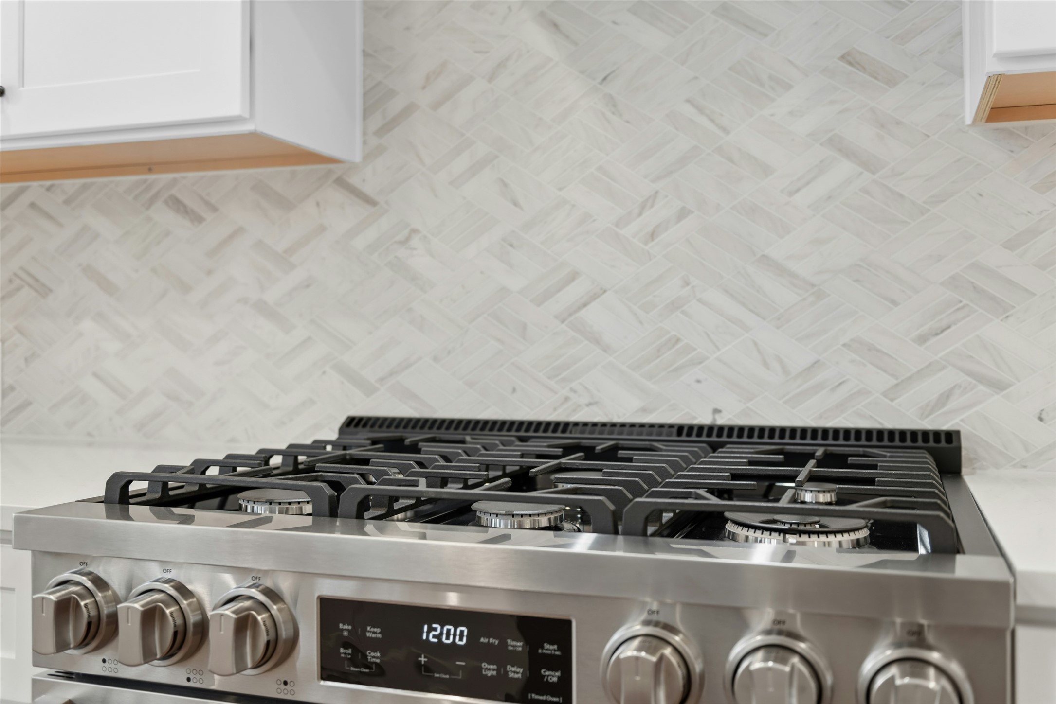 813 Caribou Ridge Trail Pflugerville, TX 78660 - Photo 4 of 39 Professional 36-inch six-burner gas range with designer herringbone tile backsplash, creating a true chef’s kitchen centerpiece.