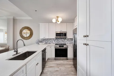 a kitchen with cabinets a sink and a stove top oven