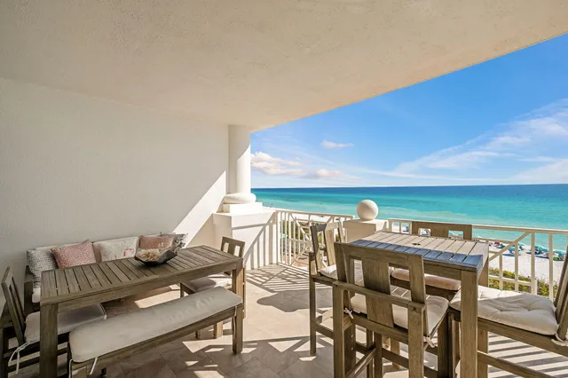 a dining room with furniture and a floor to ceiling window