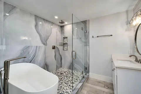 a bathroom with a granite countertop sink a toilet and shower