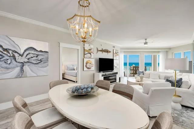 a living room with furniture a chandelier and a flat screen tv