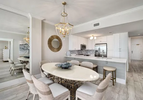 a view of a dining room with furniture a chandelier and wooden floor