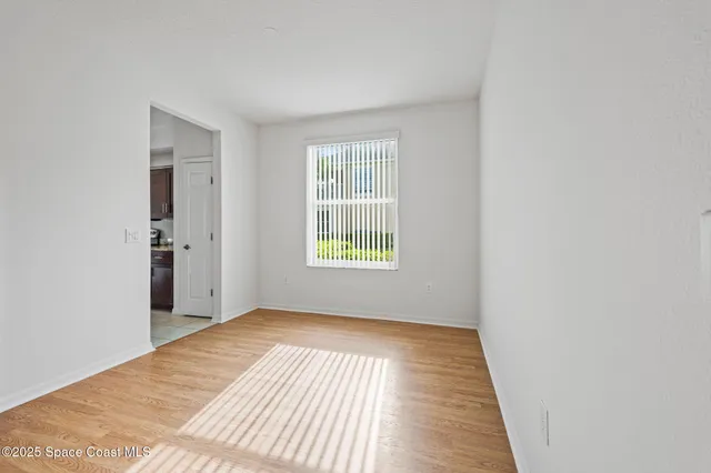 a view of a room with wooden floor and a window