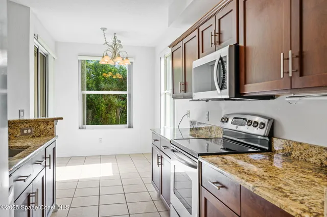a kitchen with stainless steel appliances granite countertop a sink stove and cabinets