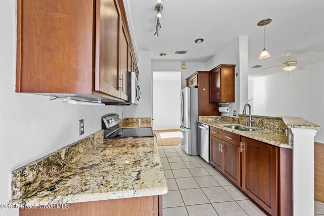 a kitchen with stainless steel appliances granite countertop a stove a sink and a microwave