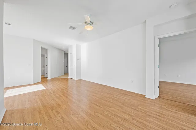 a view of an empty room with wooden floor