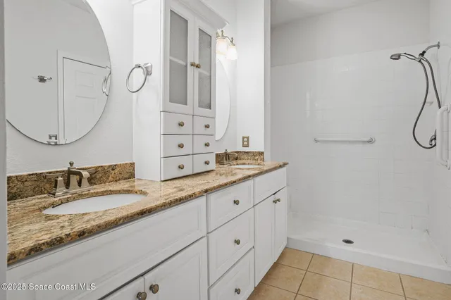 a bathroom with a granite countertop sink mirror and a shower