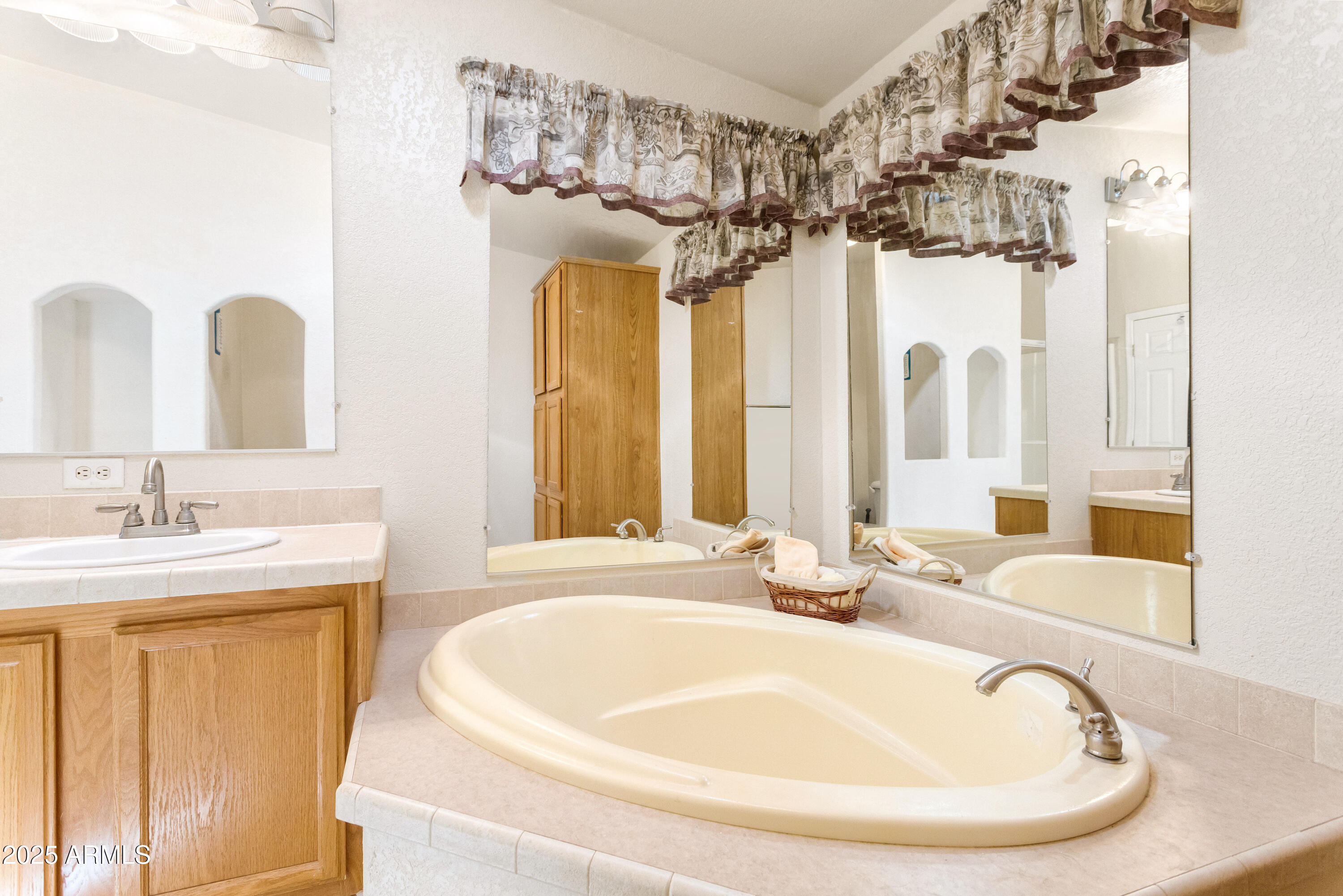 3526 West Rak Road Douglas, AZ 85607 - Photo 18 of 51 a bathroom with a tub sink and mirror