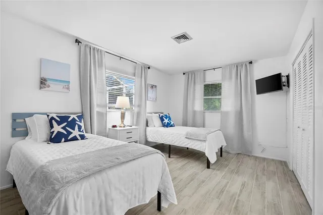 a bedroom with two beds and a large window